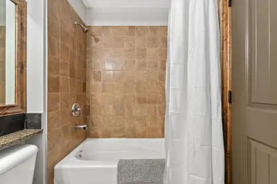 a bathroom with a tub and a shower curtain at Grizzly Springs, Outdoor Pool, Hot Tub, Fireplace in Radium Hot Springs