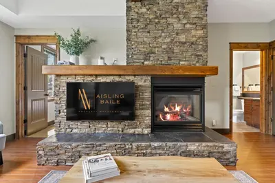 a living room with a fireplace with a roaring fire at Grizzly Springs, Outdoor Pool, Hot Tub, Fireplace in Radium Hot Springs