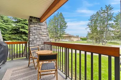 a porch with two chairs and a table on it at Grizzly Springs, Outdoor Pool, Hot Tub, Fireplace in Radium Hot Springs