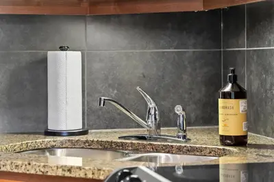 a kitchen counter with a sink and a bottle of wine at Grizzly Springs, Outdoor Pool, Hot Tub, Fireplace in Radium Hot Springs
