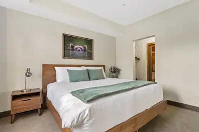 a bedroom with a large bed with a dog picture on the wall at Grizzly Springs, Outdoor Pool, Hot Tub, Fireplace in Radium Hot Springs