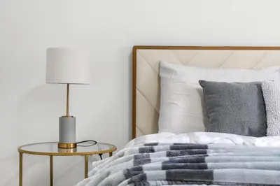 a bedroom with a bed and a table with a lamp at LUXURY LAKEVIEW HOME - 2500sqft of private space with 5 Beds, 4 Bath, 2 Living Rooms, Kitchen, AC, Jacuzzi, 10 Guests Max, Basement Not Included, 18-min to Airport, 20-min to Downtown, 80-min to Banff in Calgary
