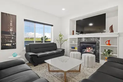 a living room with two couches and a fireplace at LUXURY LAKEVIEW HOME - 2500sqft of private space with 5 Beds, 4 Bath, 2 Living Rooms, Kitchen, AC, Jacuzzi, 10 Guests Max, Basement Not Included, 18-min to Airport, 20-min to Downtown, 80-min to Banff in Calgary