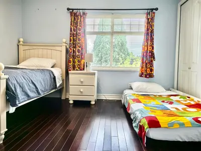 a bedroom with two beds and a window at Cozy Guest Rooms Near UBC, Downtown and Beaches in Vancouver
