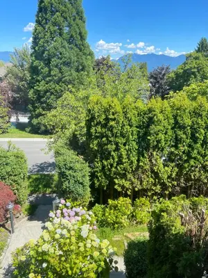 a garden with flowers and trees on a street at Cozy Guest Rooms Near UBC, Downtown and Beaches in Vancouver