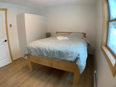 a small bedroom with a bed with a blue blanket at Eleanor Lodge - Entire House in Blue River in Blue River