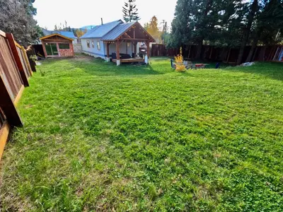 a yard with a small house in the background at Eleanor Lodge - Entire House in Blue River in Blue River