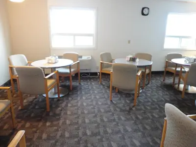 a dining room with tables and chairs and windows at South Hill Motor Inn in Red Deer