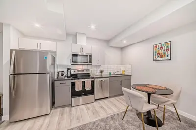 a kitchen with stainless steel appliances and a table at Cozy Basement Suite in Calgary