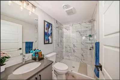 a bathroom with a sink and a toilet and a shower at Cozy Basement Suite in Calgary