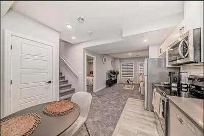 a kitchen and dining room with a table and appliances at Cozy Basement Suite in Calgary