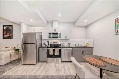a kitchen with stainless steel appliances and a table at Cozy Basement Suite in Calgary