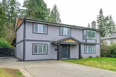 a grey house with a driveway in front of it at Private 1 bedroom in Brookswood in Langley