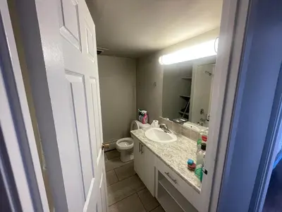 a bathroom with a sink and a toilet and a mirror at florian Apartment in Calgary
