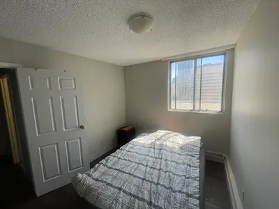 a bedroom with a bed and a window at florian Apartment in Calgary