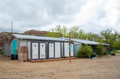 a small building with white doors and a roof at D4 Badlands Bunker Dome- 1 Queen Pet Friendly in Drumheller