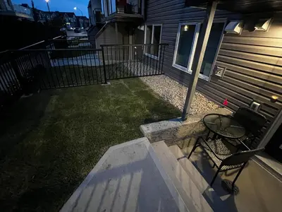 a patio with a table and a bench next to a house at The Haven - cozy 1 bedroom suite in Seton SE Calgary in Calgary