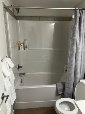 a bathroom with a white tub and a toilet at The Haven - cozy 1 bedroom suite in Seton SE Calgary in Calgary