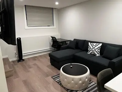 a living room with a couch and a table at The Haven - cozy 1 bedroom suite in Seton SE Calgary in Calgary