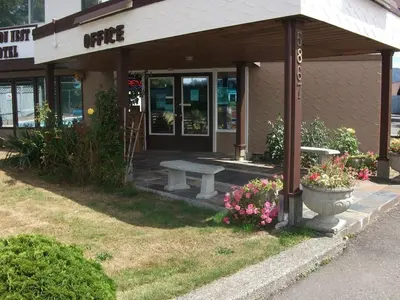 a bench in front of a building with flowers at Falcon Nest Motel in Duncan