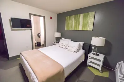 a bedroom with a large bed and a flat screen tv at HI Calgary City Centre - Hostel in Calgary