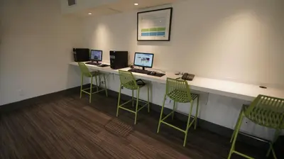 a waiting room with four chairs and a counter with computers at HI Calgary City Centre - Hostel in Calgary