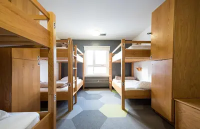 a room with three bunk beds and a window at HI Calgary City Centre - Hostel in Calgary