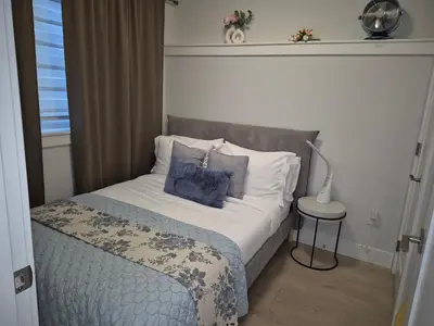 a bedroom with a bed with pillows and a lamp at Cozy Private Suite near YVR Airport in Vancouver