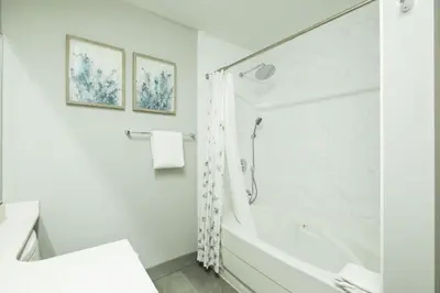 a white bathroom with a tub and a shower at Symphony by Outpost Whistler in Whistler