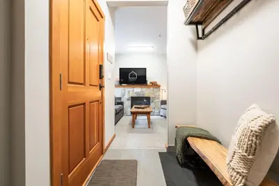 a hallway with a door leading to a living room at Symphony by Outpost Whistler in Whistler