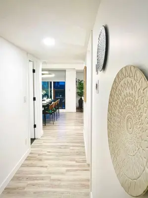 a hallway leading to a dining room with a clock on the wall at T201 Brand NEW Downtown Canmore 3BD & 2BT, BBQ, Free Parking in Canmore