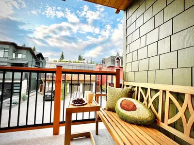 a wooden bench sitting on a balcony with a view at T201 Brand NEW Downtown Canmore 3BD & 2BT, BBQ, Free Parking in Canmore
