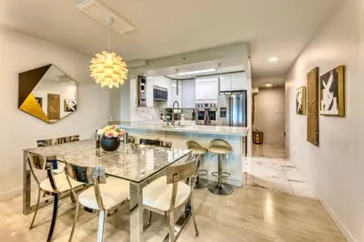 a dining room and kitchen with a glass table and chairs at Art Deco Broadway Queen Room in Vancouver