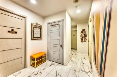 a hallway with a door and marble flooring at Art Deco Broadway Queen Room in Vancouver
