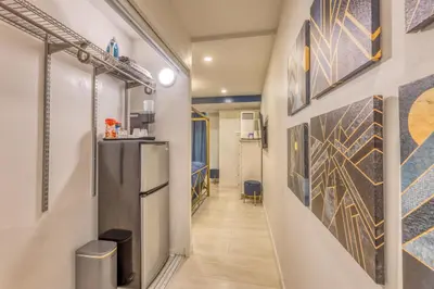 a hallway with art on the wall and a refrigerator at Art Deco Broadway Queen Room in Vancouver