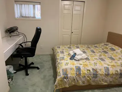 a bedroom with a bed and a desk and a chair at Near Downtown YVR -2 Bedroom private suite in Vancouver