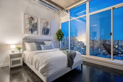 a bedroom with a bed and a large window at Studio Just Steps from Stampede Park, Luxury Living in Calgary