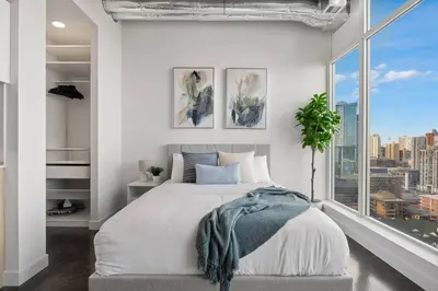 a bedroom with a large bed and a large window at Studio Just Steps from Stampede Park, Luxury Living in Calgary