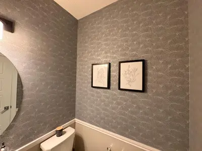 a bathroom with gray walls with a toilet and a mirror at Z FamilyHome Suites & Apartments in Calgary