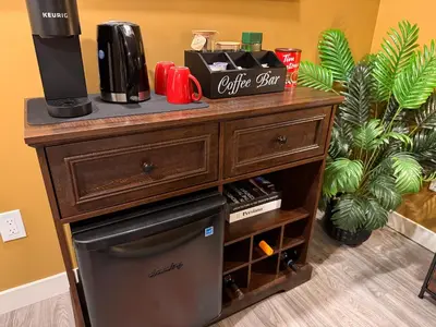a wooden dresser with a coffee maker on top of it at Z FamilyHome Suites & Apartments in Calgary