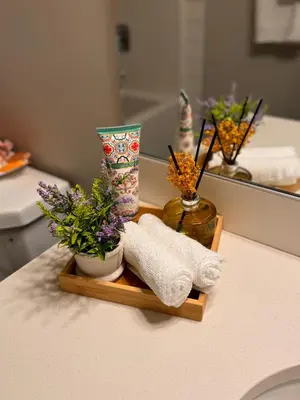 a wooden tray with towels and flowers on a bathroom counter at Z FamilyHome Suites & Apartments in Calgary