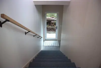 a stairway with a hand rail and a stair case at WHITE HAUS w private sauna and close to beach in Ucluelet