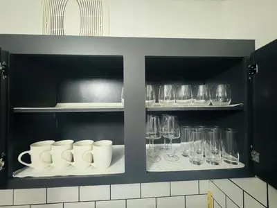a kitchen with cups and wine glasses on shelves at Entire Apartment Prime Downtown location Free underground Parking in Calgary