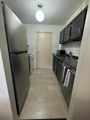 a kitchen with a stainless steel refrigerator and a hallway at Entire Apartment Prime Downtown location Free underground Parking in Calgary