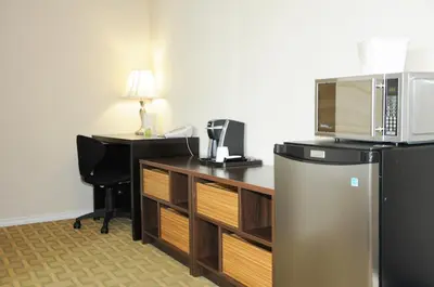 a room with a desk with a microwave on top of it at High Point Inn & Suites Peace River in Peace River