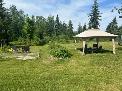 a gazebo with a table and chairs in a field at Cozy cabin in Clearwater