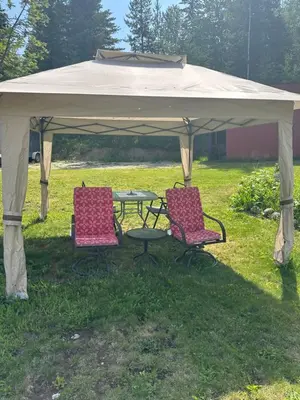 two chairs and a table under a gazebo at Cozy cabin in Clearwater