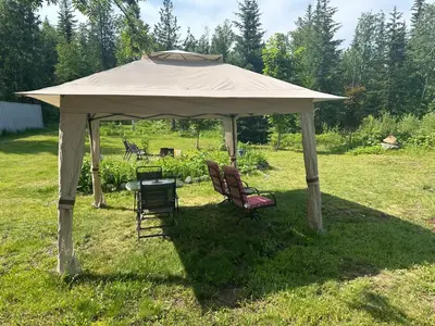a tent with two chairs and a table in a field at Cozy cabin in Clearwater