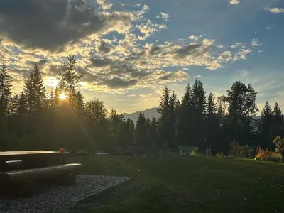 a bench sitting in a park with the sun setting at Cozy cabin in Clearwater