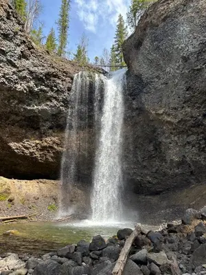 a waterfall on the side of a mountain with rocks at Cozy cabin in Clearwater